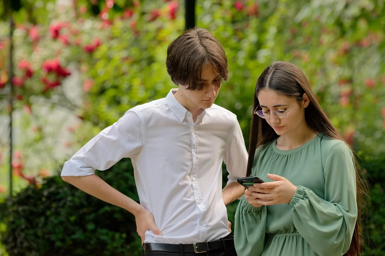 people, young, coup, girlie, boy, looking, together, smartphone, outdoors, naturally, parka. How to vet Gen Z content marketing benchmarks