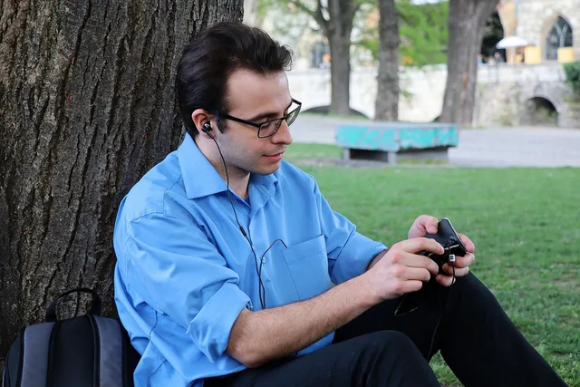 portrait, park, men's, young, person, adult, facial, hair, nature, submerged, music, listening to music, phone, smart phone, shirt, blue, dress, pants, glasses. What separates the strong Gen Z marketing strategy examples from the weak