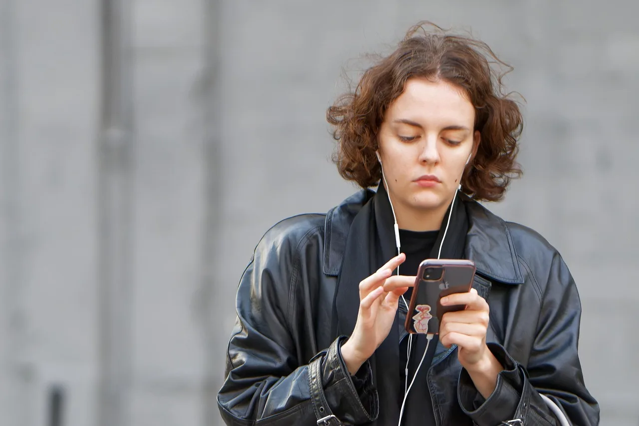 woman, young, smartphone, watching, listening, earphones, outdoors, urban. 4 things nobody tells you about Gen z marketing strategy mistakes
